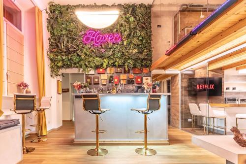 a bar in a restaurant with stools at Haven Loft Como - Private Spa, Parking & Jacuzzi in Como