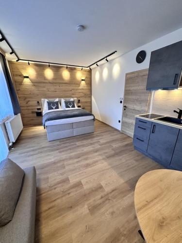 a bedroom with a bed and a wooden wall at Alpin Studio Haus, Kaibling & Ski amadé in Haus im Ennstal