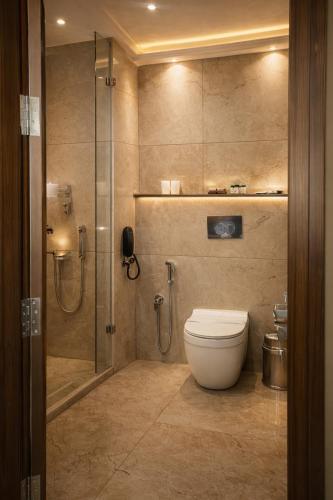 a bathroom with a toilet and a glass shower at Blue Diamond Residency in Perintalmanna
