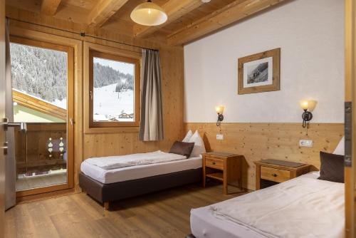 a hotel room with two beds and a window at Gamsalm in Kals am Großglockner