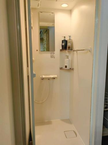 a shower with a glass door in a bathroom at ゲストハウス瓦町 in Takamatsu