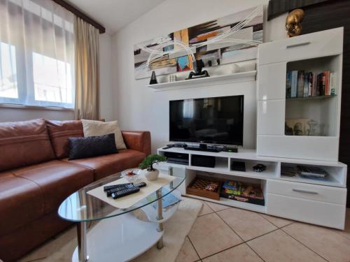 a living room with a couch and a tv at Nova Residence in Pula