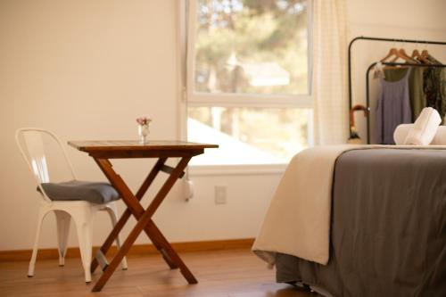 a bedroom with a table and a bed and a window at Diez Pinos in Punta del Este