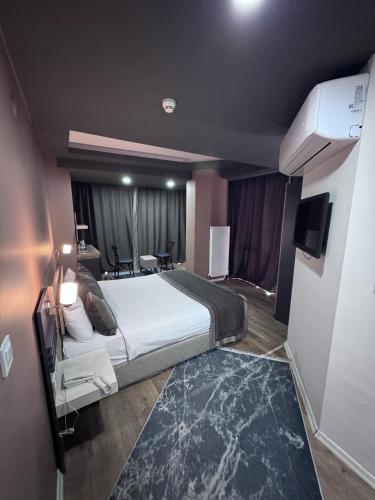a hotel room with a large bed and a television at The Montana City Hotel in Bostaniçi