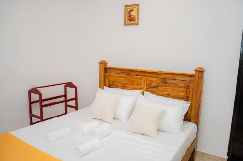a bedroom with a white bed with white pillows at Zeylon Villa Talalla in Matara