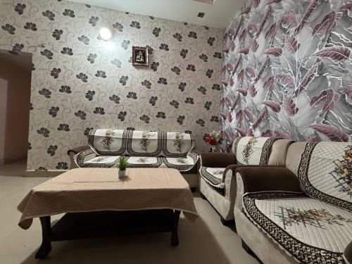 a living room with two couches and a table at Karuna Homestay in Ujjain