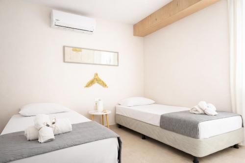 two beds in a bedroom with white walls at Haroupia The Residence in Kalidhón
