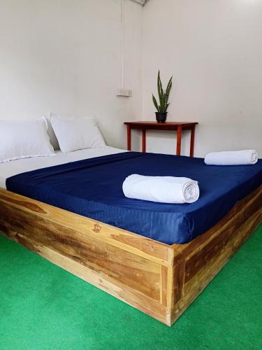 a bedroom with a large bed with a blue mattress at Wave Hunters Arugam Bay in Arugam Bay