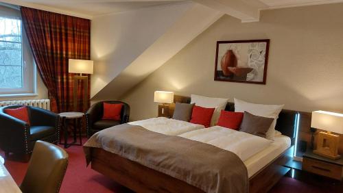 a hotel room with a large bed and chairs at Hotel Weiße Taube in Döbeln
