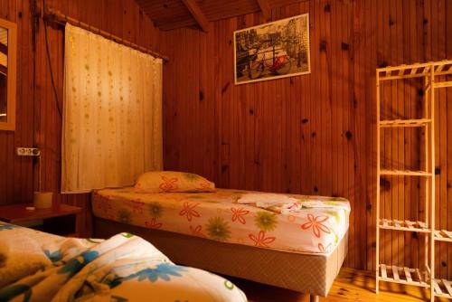 a bedroom with two beds in a wooden room at Olympos Yakamoz Pansiyon in Olympos