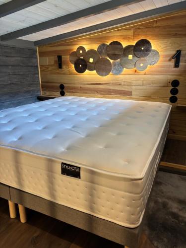 un matelas dans une pièce aux murs en bois dans l'établissement TiNY HOUSE LE CHALET, à Échenoz-la-Méline