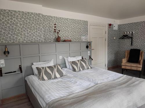 a bedroom with a large bed and a chair at Lilla Hotellet in Lund