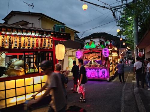 a group of people walking down a street with a float at 101個室元芸者の隠れ宿湯河原 in Yugawara