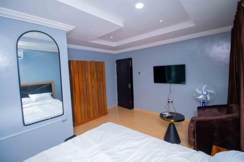 a bedroom with a bed and a mirror and a couch at Living Space Apartment in Ibadan