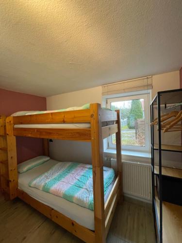 a bunk bed room with two bunk beds and a window at FeWo Renken in Trassenheide