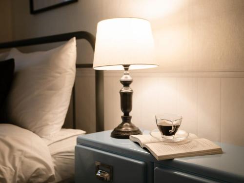 a lamp and a glass of wine on a table next to a bed at Atelier7419 Songpa in Seoul