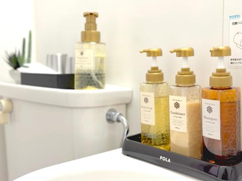 three bottles of soap sitting on top of a bathroom sink at JindaijiStudio SAZU222 in Chofu
