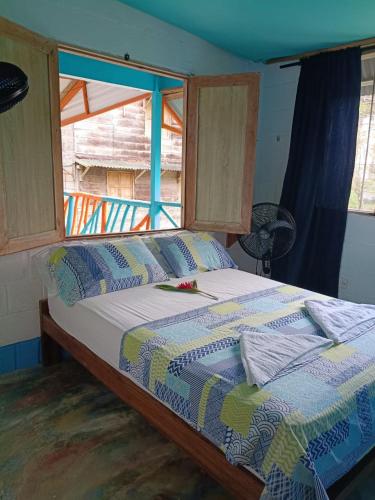 a large bed in a room with a window at Casa hostal playa coral in Capurganá