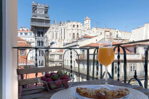 a table with a plate of food and a glass of wine at Ando Living - Santa Justa 79 House in Lisbon