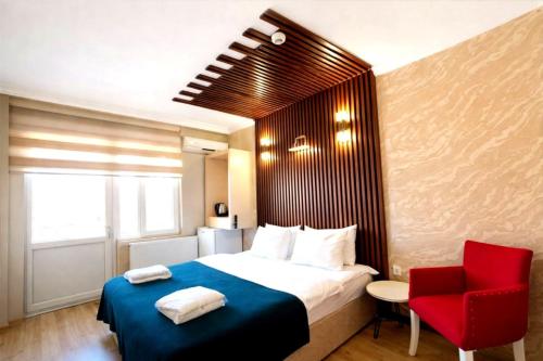 a hotel room with a bed and a red chair at Koc Hotel in Karasu