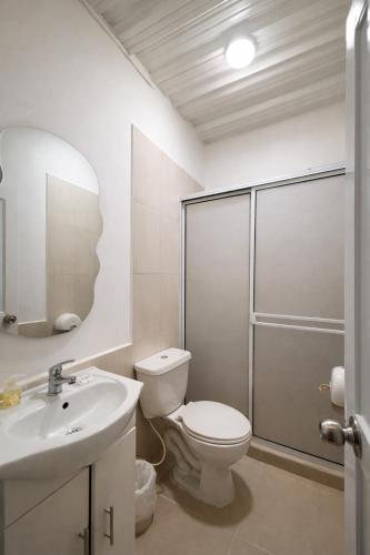 a bathroom with a toilet and a sink and a shower at Hotel Palmera Beach in Cartagena de Indias