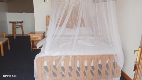 a bed with a canopy in a room at Hotel White Sandcastle Mara in Sekenani