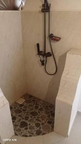 a shower with a hose in a bathroom at Hotel White Sandcastle Mara in Sekenani