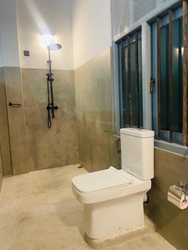 a bathroom with a white toilet in a room at Far view villa in Galle