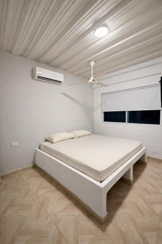 a white bedroom with a bed and a ceiling at Hotel Palmera Beach in Cartagena de Indias