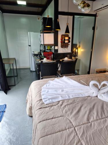 a bedroom with a bed with two white towels on it at 2210 CadBox Suíte, Hidro, Churrasqueira, Cozinha Privativo in Sao Jose do Rio Preto