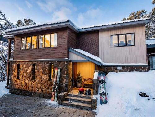 a home in the snow with skis in the yard at Luxury Mt Buller Ski Chalet Fireplace Sleeps 14 in Mount Buller