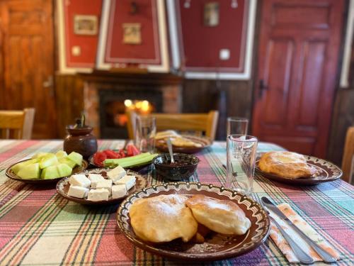 a table with plates of food on top of it at Nenchova Guest House in Koprivshtitsa