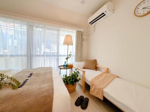 a bedroom with two beds and a window at Sky Home新宿 in Tokyo