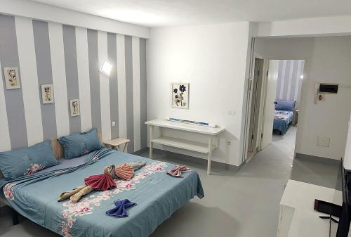 a bedroom with a blue bed and a desk at Pensão Big Game Maio Vila do Maio in Vila do Porto