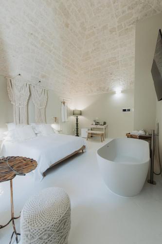 a bedroom with a large bed and a bath tub at Palazzo Mimì in Bitritto