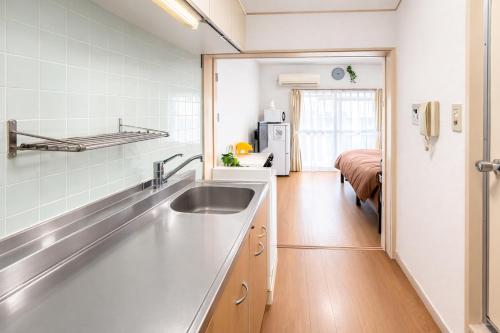 a kitchen with a sink and a refrigerator at ひまわり in Dazaifu