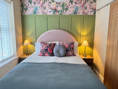a bedroom with a bed with pillows and a headboard at Haven House Rooms, Barry in Barry