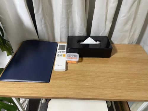 a table with a remote control and a box on it at 101個室元芸者の隠れ宿湯河原 in Yugawara