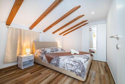a bedroom with a bed and a wooden floor at Bistra Pakoštane Apartments in Pakoštane