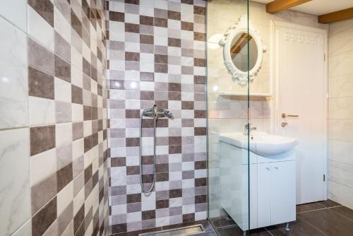 a bathroom with a checkeredkered wall at Bistra Pakoštane Apartments in Pakoštane