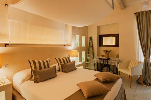 a bedroom with a large white bed with two pillows at Masseria Messapia Wine Resort & Spa Salento in Mesagne