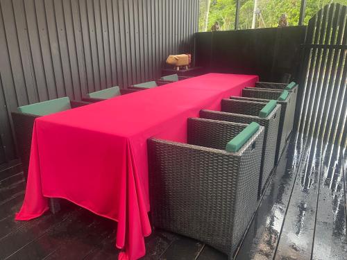 a table with a red table cloth and chairs at Vacation Rental Motobu Grande BBQ機材完備 2卫 4车位 15人 in Motobu