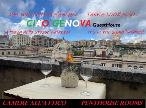 two wine glasses on a table with a view of a city at VITTORIA ROOMS GuestHouse - the Original since 2015 in Genoa