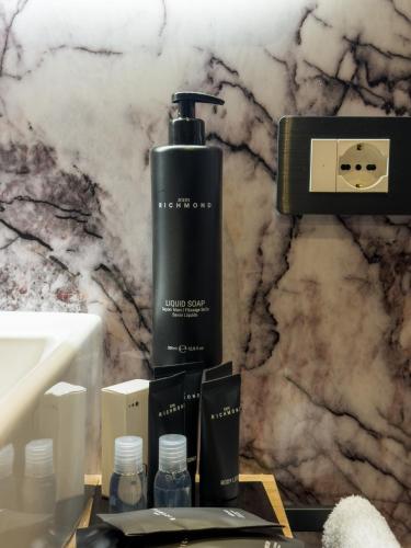 a black bottle of soap on a table next to a counter at Il Tempio Luxury Rooms in Cosenza