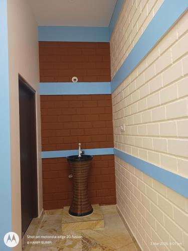 a bathroom with a toilet in a brick wall at Smarami homestay in Hospet