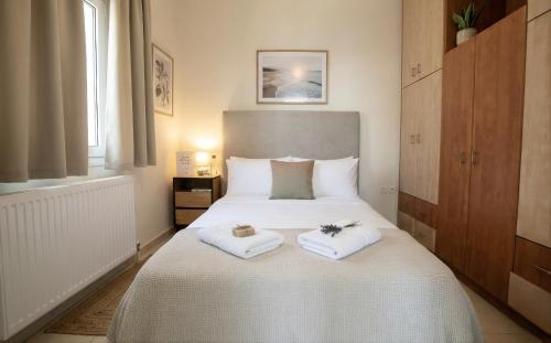 a bedroom with a large white bed with towels on it at Vignetta Mare 2BR Villa με Θέα & και Ιδιωτικό Πάρκινγκ in Ermoupoli
