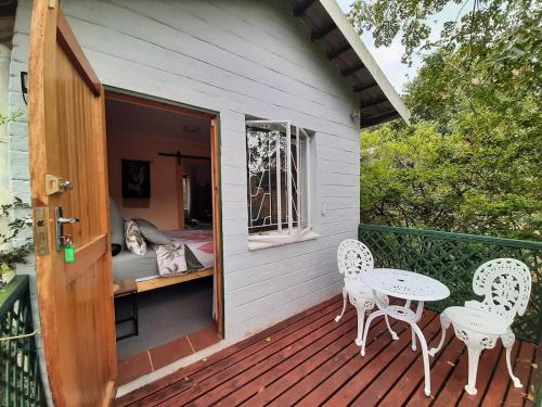 a patio with two chairs and a table on a porch at Birdsong Cottage in Howick