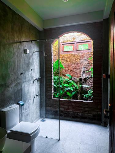 a bathroom with a window and a toilet in it at Trinco Beach Bunks in Trincomalee
