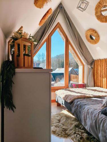 a bedroom with a bed and a large window at Lux Houses w DOMKU tylko DWA APARTAMENTYz jacuzzi zewnętrznym in Groń