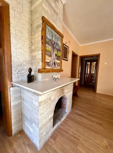 a stone fireplace in a living room with a picture at Villa Piste - Skadar Lake in Virpazar
